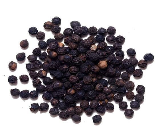 Black Pepper A detailed image of black pepper piled on a white surface.