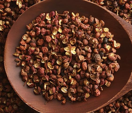 Sichuan Pepper A detailed view of Sichuan pepper with a wooden spoon.
